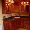 Cedar bathroom cabinets with arched top glass doors; laminate top with wood edges