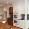 White and stained maple cabinets with double ovens, wine rack and post incorporated