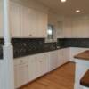 White kitchen cabinets with bead board doors and angled end cabinet with post