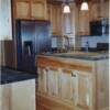 Natural maple kitchen cabinets with light and dark wood; marble countertop