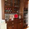 Dark stained cherry kitchen cabinets with glass doors & wine rack; ovens incorporated